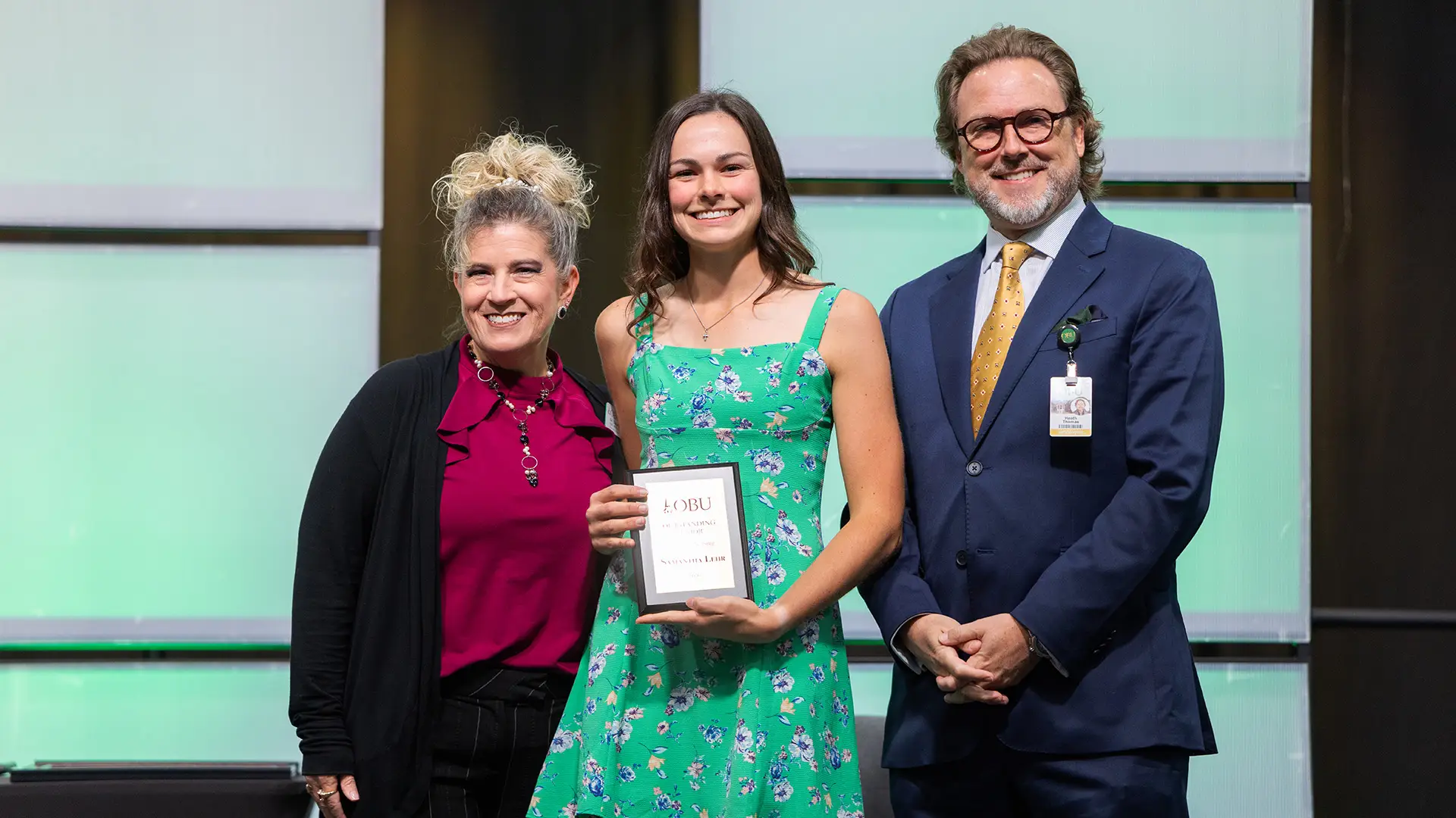 Dr. Stephanie Parker, chair of the School of Nursing, left, and OBU President Dr. Heath A. Thomas, right, presented the Outstanding Senior Award from the School of Nursing to Samantha Lehr, center.