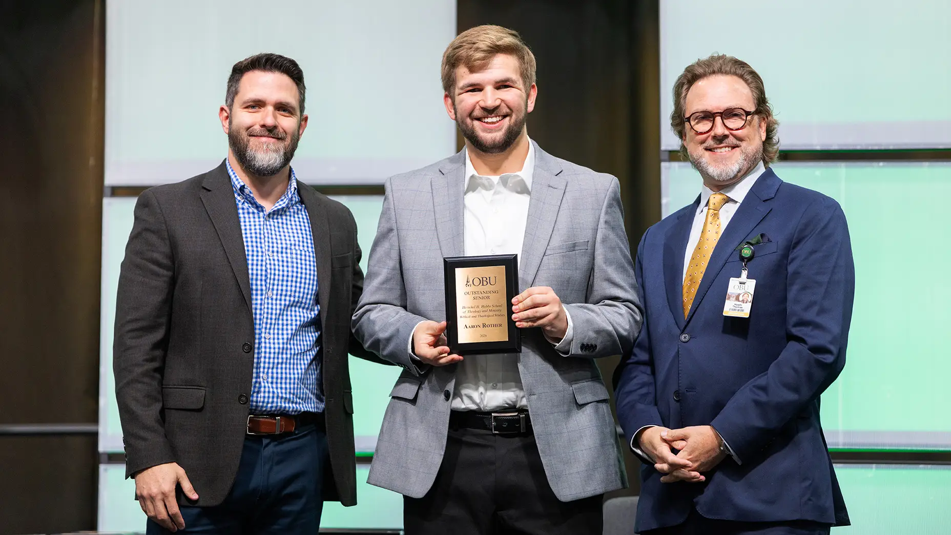 Dr. Brandon D. Smith, chair of the Herschel H. Hobbs School of Theology and Ministry, left, and OBU President Dr. Heath A. Thomas, right, presented the Outstanding Senior Award in biblical and theological studies to James Rother, center.