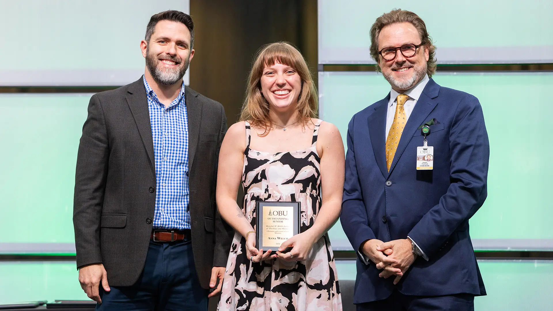 Dr. Brandon D. Smith, chair of the Herschel H. Hobbs School of Theology and Ministry, left, and OBU President Dr. Heath A. Thomas, right, presented the Outstanding Senior Award in Christian and cross-cultural ministry to Anna Welch, center.