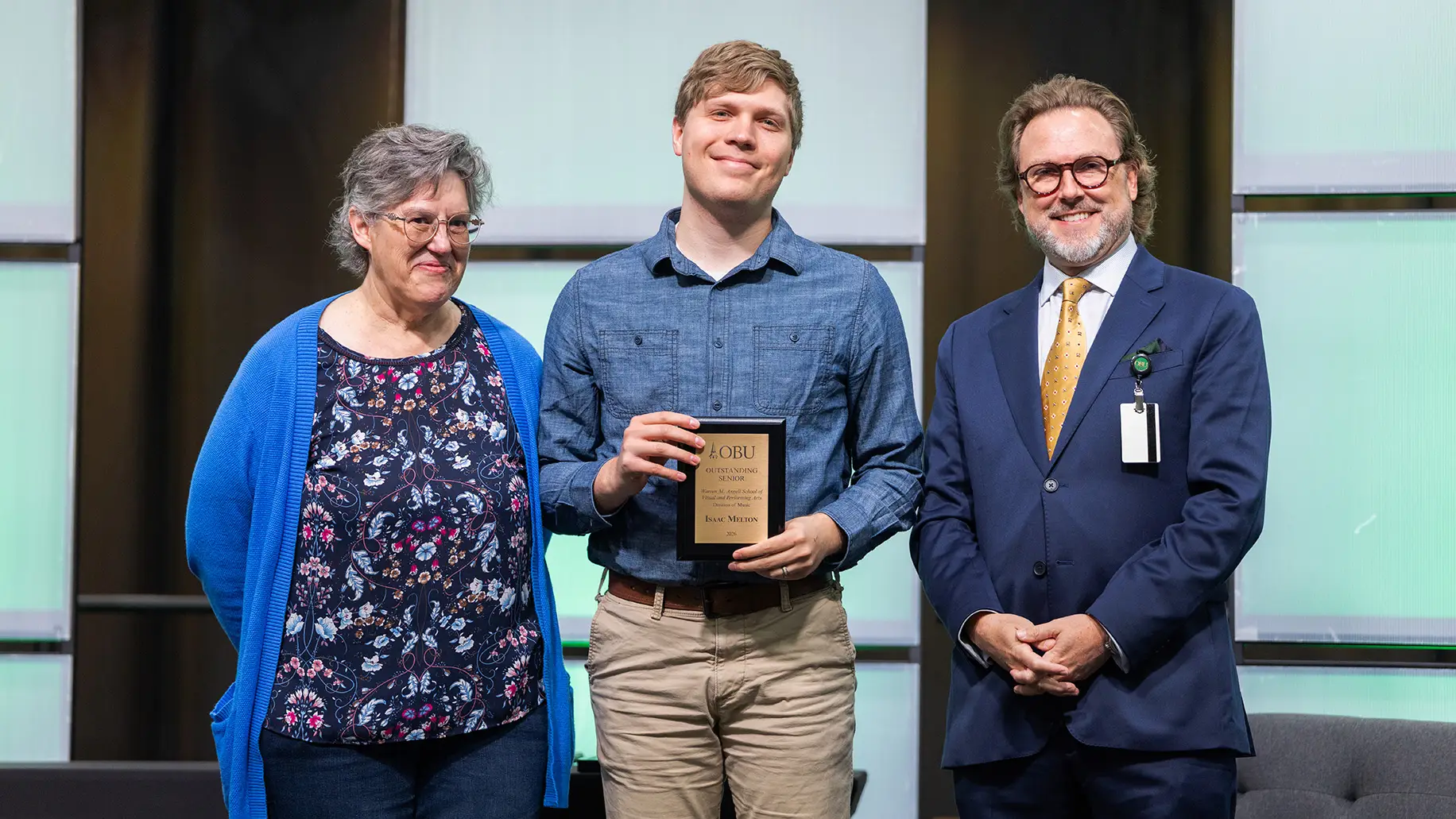 Dr. Patty K. Nelson, chair of the Division of Music, left, and OBU President Dr. Heath A. Thomas, right, presented the Outstanding Senior Award from the Division of Music in the Warren M. Angell School of Visual and Performing Arts to Isaac Melton, center.