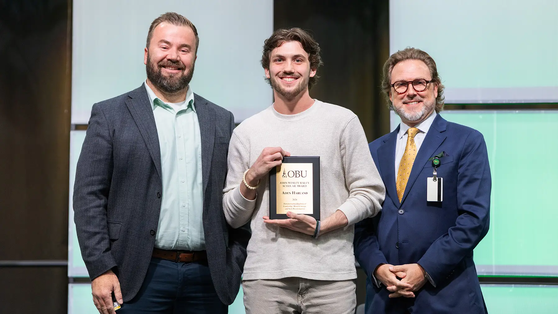 Joe Wuest, vice president of campus life, left, and OBU President Dr. Heath A. Thomas, right, presented The John Wesley Raley Scholar Award to Aden Harland, center.