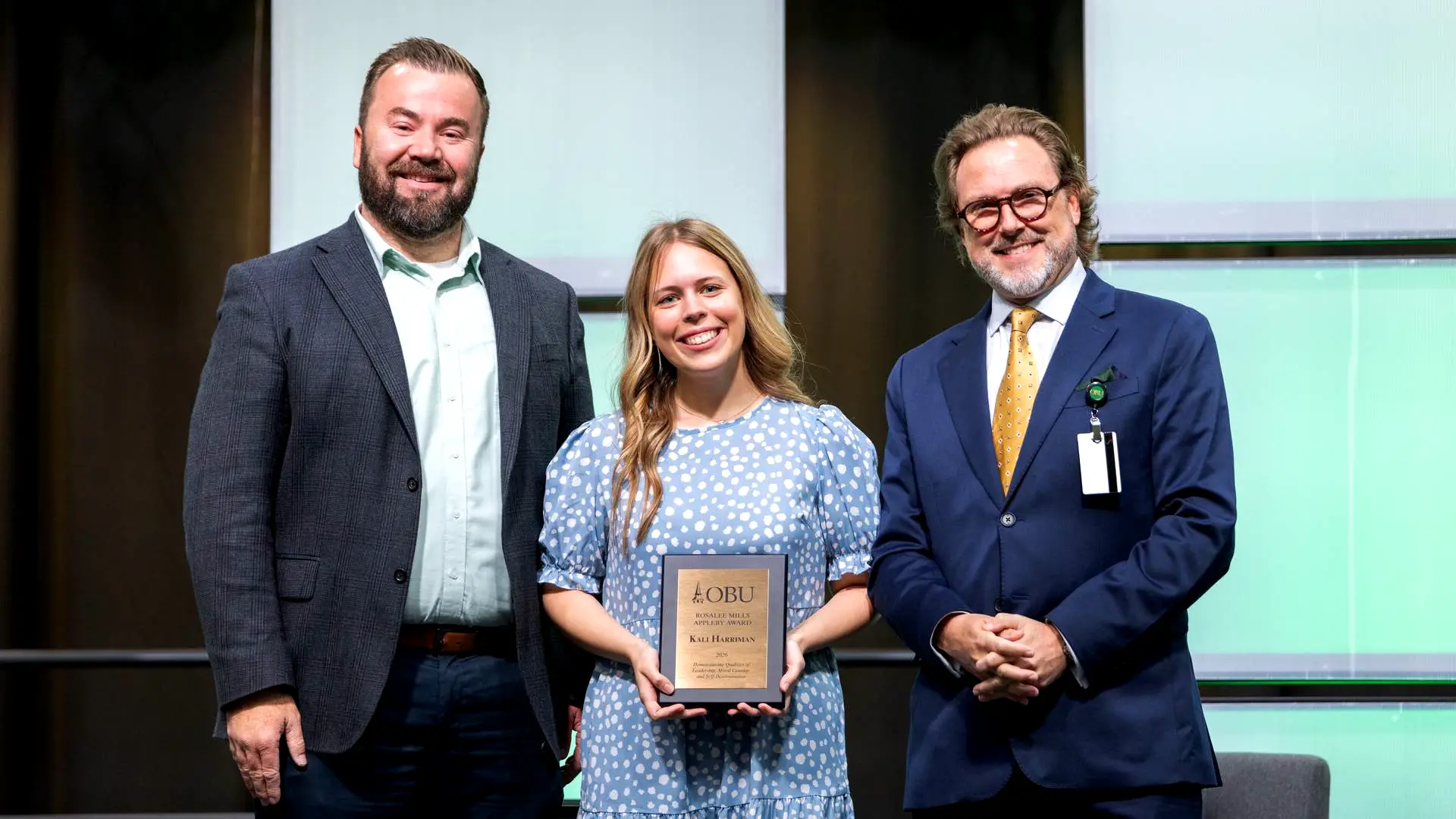 Joe Wuest, Oklahoma Baptist University vice president for campus life, left, and OBU President Dr. Heath A. Thomas presented the Rosalee Mills Appleby Award to Kali Harriman. The Rosalee Mills Appleby Award is one of the highest honors given to a senior at OBU.