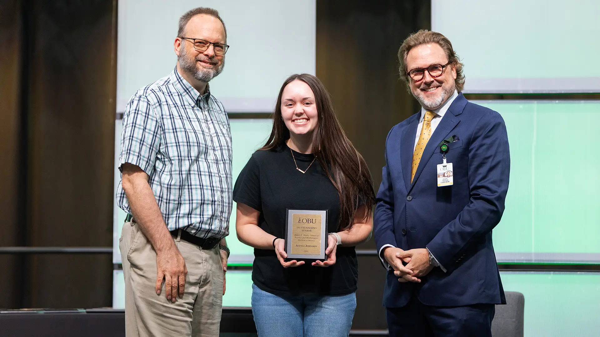 Dr. Nathan Malmberg, professor of chemistry, left, and OBU President Dr. Heath A. Thomas, right, presented the Outstanding Senior Award from the Division of Science to Alyssa Johnson, center.