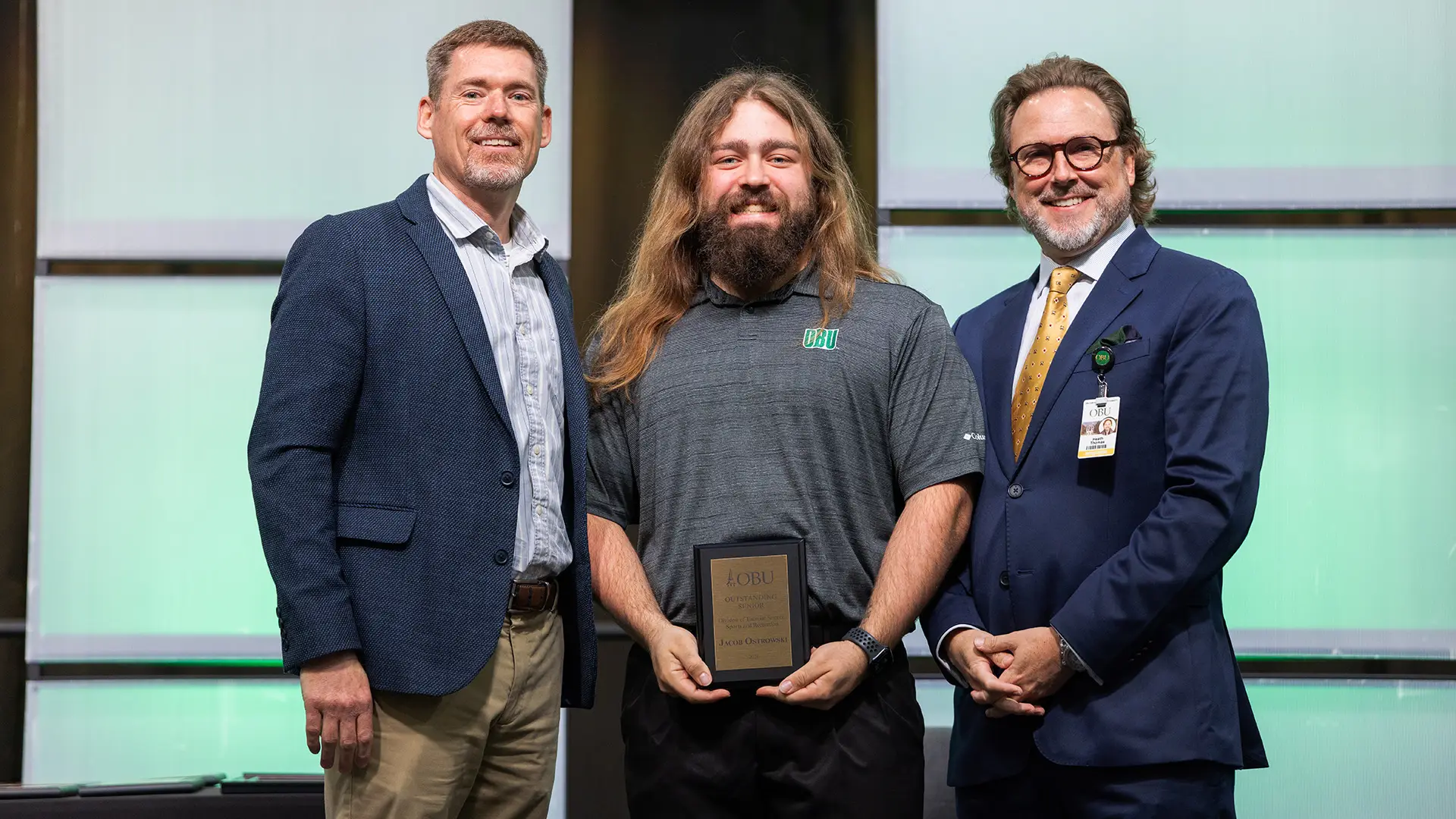 Dr. Chad Payn, chair of the Division of Exercise Science, Sports and Recreation, left, and OBU President Dr. Heath A. Thomas, right, presented the Outstanding Senior Award in exercise science to Jacob Ostrowski, center.