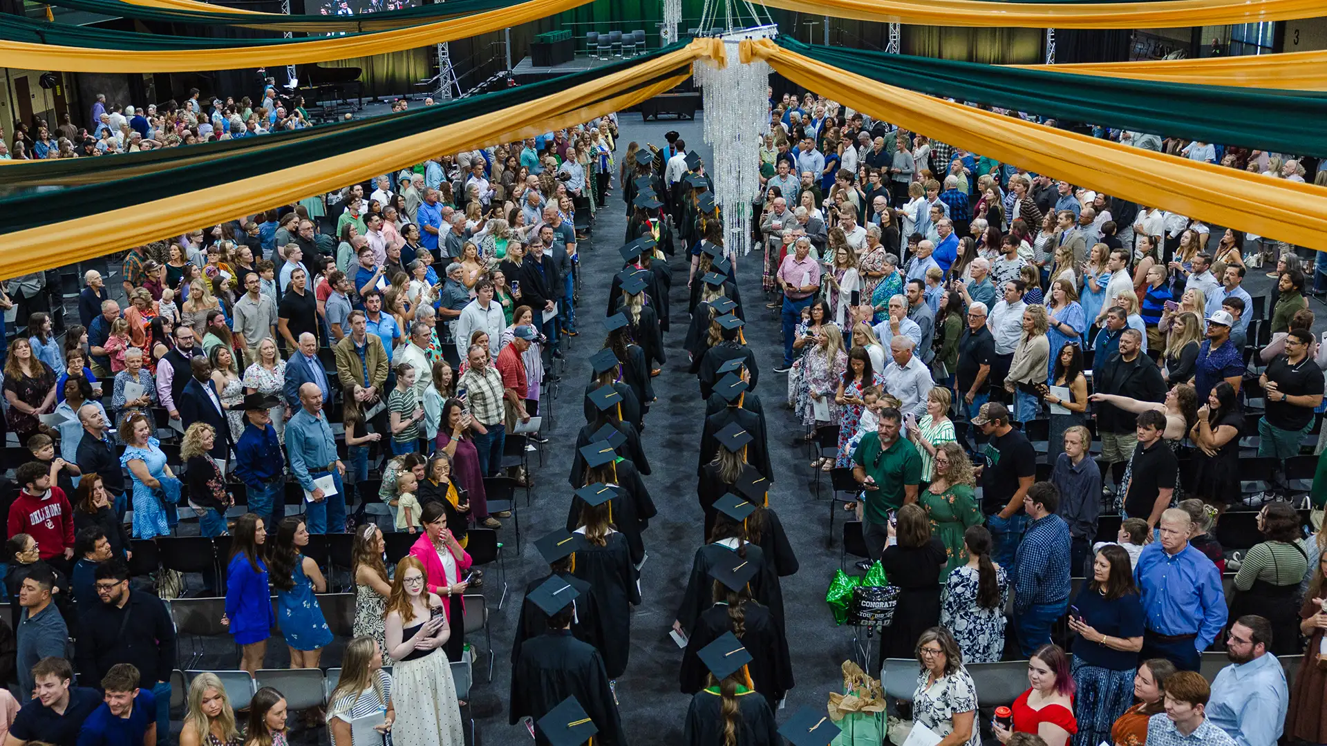Graduates walk down the aisle inside the Recreation and Wellness Center.